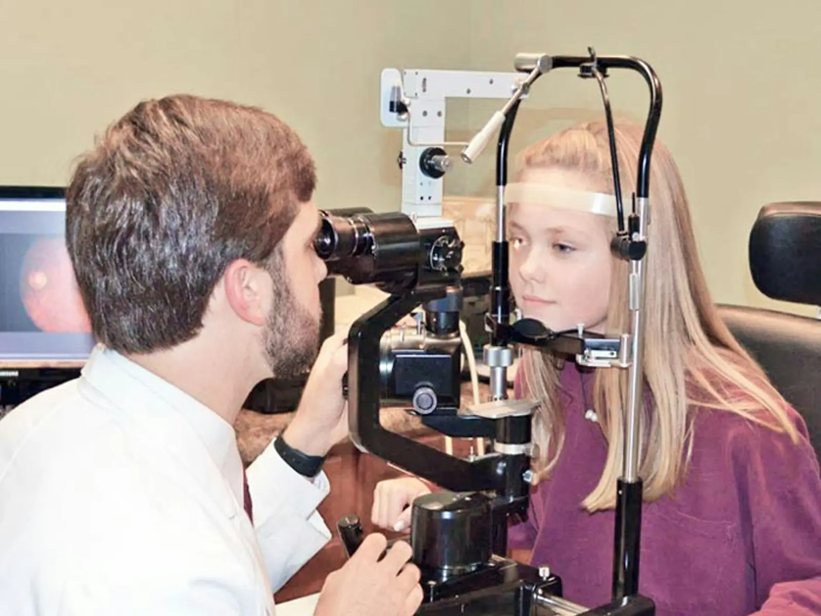 Eye doctor examining a patient at a slit lamp